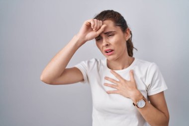 Güzel esmer kadın izole arka planda duruyor. Hastalık ve ateş için alnına dokunuyor. Grip ve soğuk algınlığı. 