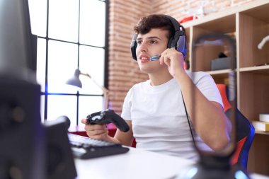 Oyun odasında joystick kullanarak video oyunu oynayan ikili olmayan adam flaması