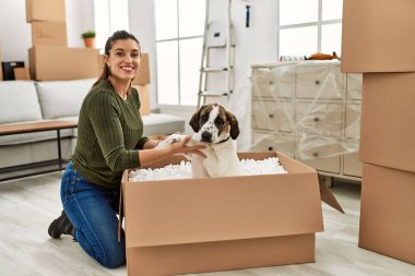 Evde köpekle oynarken kendine güvenen genç bir kadın.