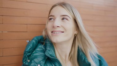 Young blonde woman smiling confident showing braces at street