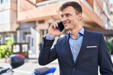 Young man business worker smiling confident talking on smartphone at street