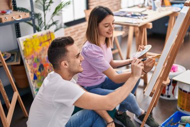 Man and woman artists couple smiling confident drawing at art studio