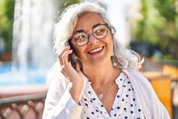 Mujer Mediana Edad Sonriendo Confiado Hablando Teléfono Inteligente Parque —  Fotos de Stock