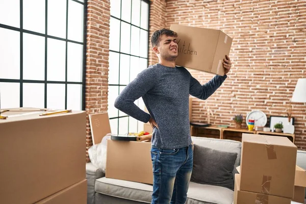 Young Hispanic Man Holding Package Suffering Backache New Home — Stockfoto