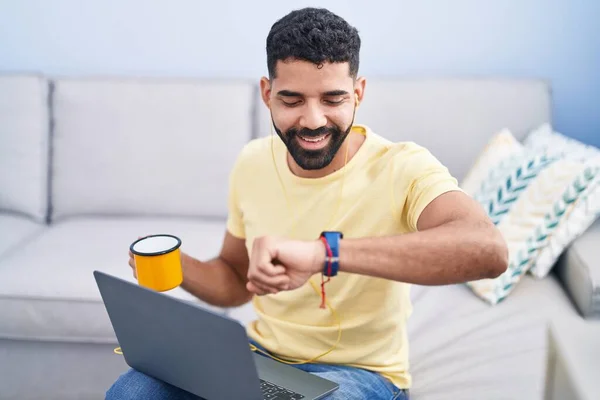 Young Arab Man Using Laptop Looking Watch Home — Stok fotoğraf