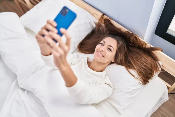 Νεαρή Γυναίκα Που Χρησιμοποιεί Smartphone Ξαπλωμένη Στο Κρεβάτι Στο Υπνοδωμάτιο — Φωτογραφία Αρχείου