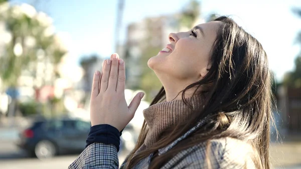 通りで目を閉じて祈る美しいヒスパニック系の女性 — ストック写真