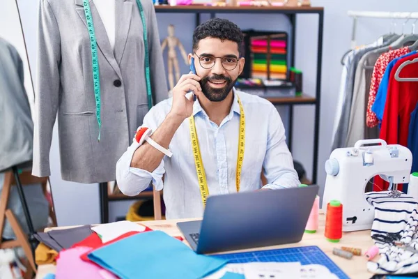Young Arab Man Tailor Talking Smartphone Using Laptop Tailor Shop — Stock Fotó