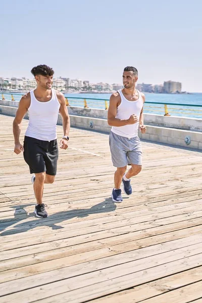 Dwóch Hiszpanów Sportowa Para Uśmiechnięta Pewnie Biegająca Nad Morzem — Zdjęcie stockowe