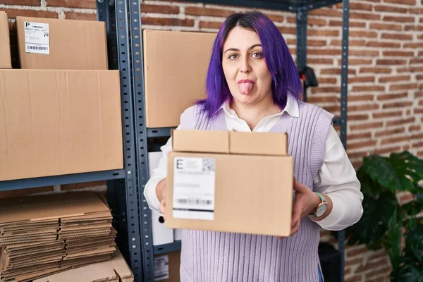 另外一个身材魁梧的女人 在小企业工作的紫色头发 手里拿着盒子 带着滑稽的表情伸出舌头 高兴极了 — 图库照片