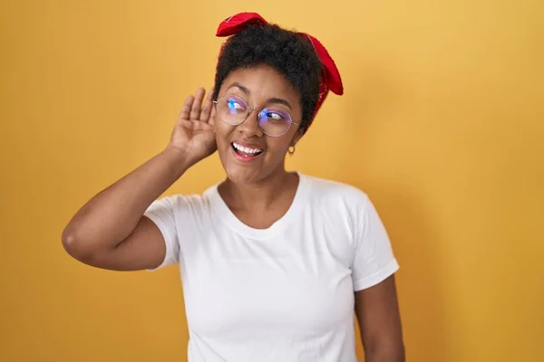 Sarı Arka Planda Dikilen Genç Afro Amerikan Kadın Kulağından Kulağa — Stok fotoğraf