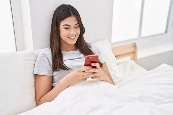 Genç Güzel Spanyol Bir Kadın Yatakta Akıllı Telefon Kullanıyor — Stok fotoğraf