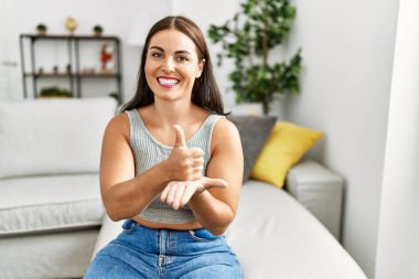 Genç ve güzel İspanyol kadın evdeki kanepede oturan sağırlarla iletişim kuruyor.