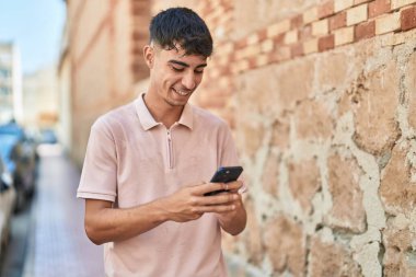Sokakta akıllı telefon kullanan, kendine güvenen genç bir İspanyol.