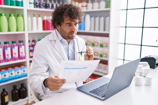 Young Hispanic Man Pharmacist Reading Prescription Using Laptop Pharmacy — Stockfoto