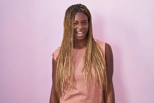 Африканская Американка Плетеными Волосами Стоит Розовом Фоне Подмигивая Глядя Камеру — стоковое фото