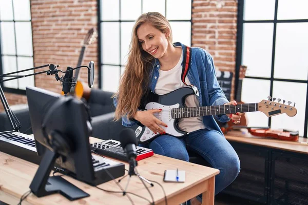 年轻的金发女音乐家在音乐工作室弹电吉他 — 图库照片