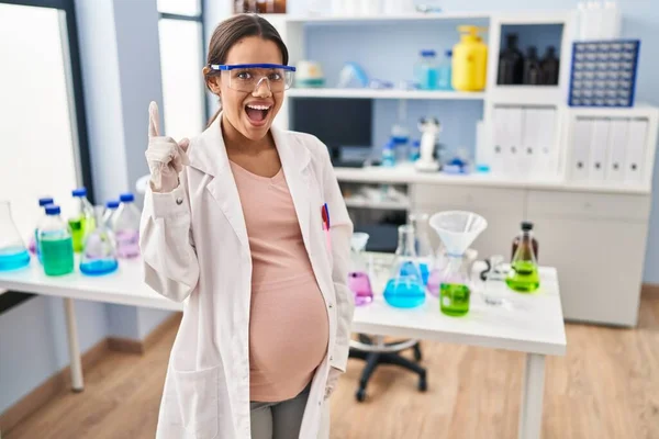 Mladá Těhotná Žena Pracující Laboratoři Vědců Ukazující Prstem Nahoru Úspěšným — Stock fotografie