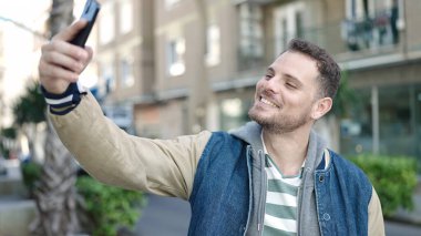 Young caucasian man smiling confident taking selfie picture at street