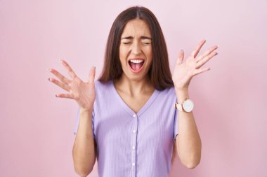 Pembe arka planda duran uzun saçlı genç İspanyol kadın kollarını kaldırmış ve gözlerini kapatmış heyecanla haykırarak başarının çılgınlığını kutluyor. Kazanan konsept 