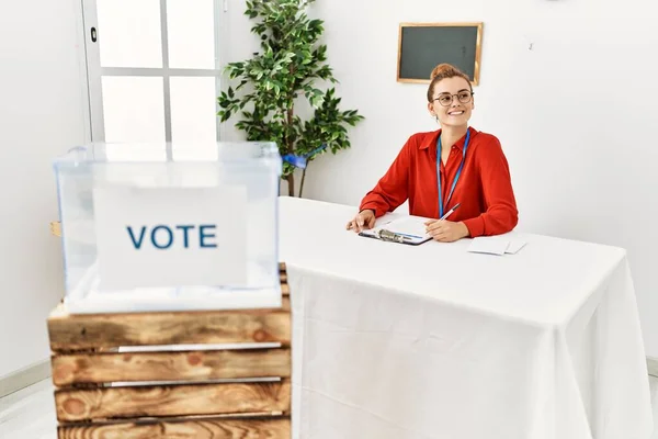 Mujer Joven Sonriendo Confiada Escribiendo Portapapeles Trabajando Colegio Electoral —  Fotos de Stock