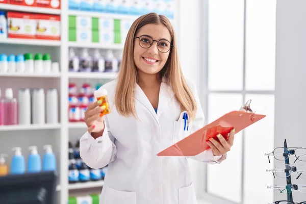 Jovem Bela Mulher Hispânica Farmacêutico Segurando Pílulas Garrafa Leitura Documento — Fotografia de Stock
