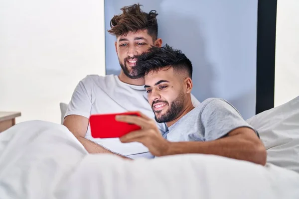Unga Par Tittar Video Smartphone Sitter Sängen Sovrummet — Stockfoto