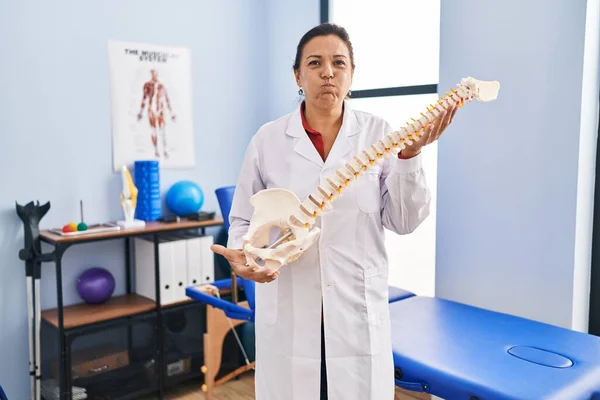 Medelålders Latinamerikanska Kvinna Håller Anatomisk Modell Ryggraden Puffande Kinder Med — Stockfoto