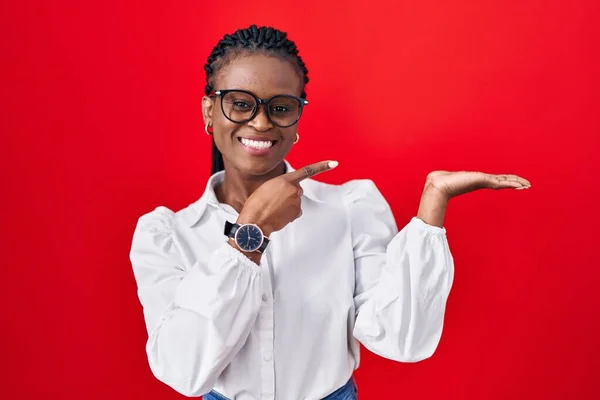 Afrikanerin Mit Zöpfen Steht Erstaunt Vor Rotem Hintergrund Und Lächelt — Stockfoto