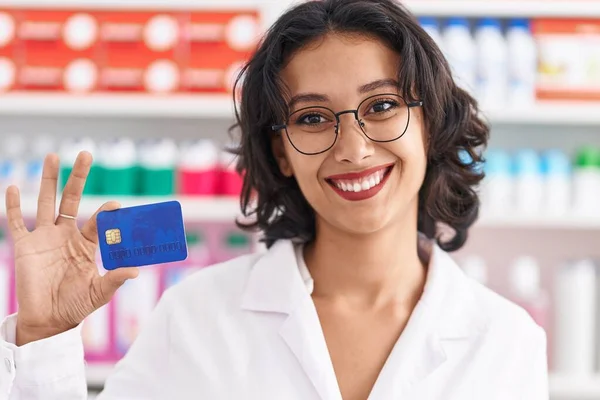 Mulher Hispânica Jovem Trabalhando Farmácia Farmácia Segurando Cartão Crédito Olhando — Fotografia de Stock
