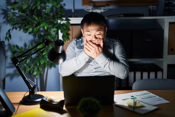 夜にコンピュータのラップトップを使用して作業している若い中国人男性は ミスのために手で口をカバーショックを受けました 秘密の概念 — ストック写真
