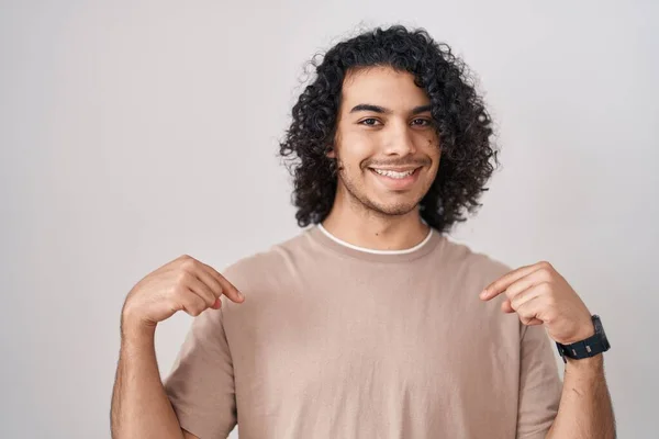 Hispanischer Mann Mit Lockigem Haar Steht Vor Weißem Hintergrund Und — Stockfoto
