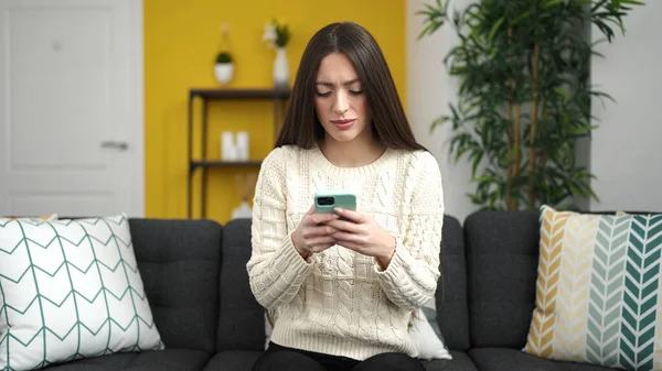 Young Beautiful Hispanic Woman Using Smartphone Serious Expression Home — Stock Photo, Image