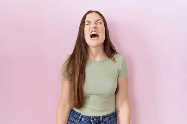 Beautiful Brunette Woman Standing Pink Background Angry Mad Screaming Frustrated — Photo