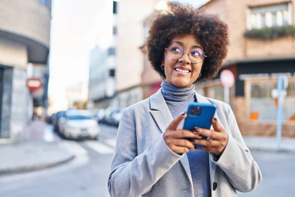 在街上用智能手机自信地微笑着的非裔美国女性高管 — 图库照片