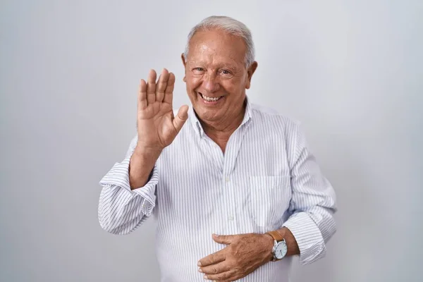 Starší Muž Šedivými Vlasy Stojící Nad Izolovaným Pozadím Vzdávající Pozdravu — Stock fotografie