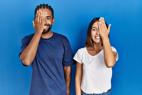 Young Hispanic Couple Standing Together Covering One Eye Hand Confident — Stok fotoğraf