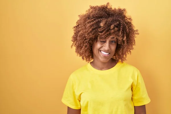 Young Hispanic Woman Curly Hair Standing Yellow Background Winking Looking — Stock Photo, Image