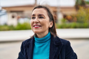 Middle age woman business executive smiling confident standing at street