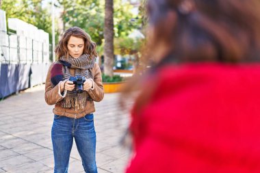 Two women mother and daughter using professional camera at park