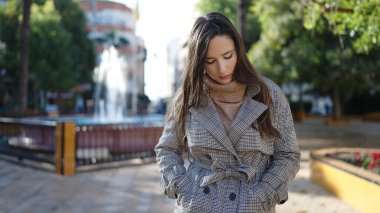 Parkta endişeli bir ifadeyle duran güzel İspanyol kadın.