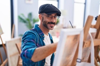Young hispanic man artist smiling confident drawing at art studio