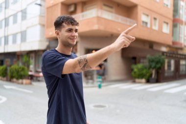 Genç İspanyol adam gülümsüyor. Kendine güveni tam. Sokakları işaret ediyor.