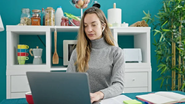 若い白人女性を使用してノートパソコンで深刻な表現でダイニングルーム — ストック写真