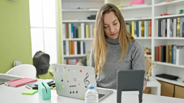 図書館大学でノートパソコンとタッチパッドを使って学ぶ若い白人女性学生 — ストック写真