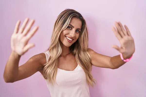 Young Blonde Woman Standing Pink Background Showing Pointing Fingers Number — Stock fotografie