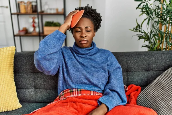 Afrikansk Amerikansk Kvinne Med Varmtvannsbag Hodet Sittende Sofaen Hjemme – stockfoto