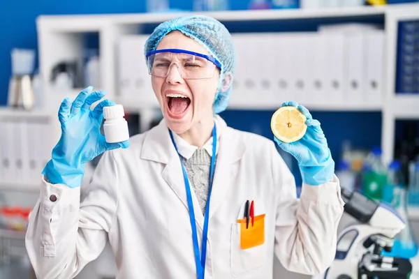 薬を持っている科学研究所で働く美しい女性とレモン怒っていると怒っている叫び不満と激怒 怒りで叫んで 怒りと攻撃的な考え方 — ストック写真