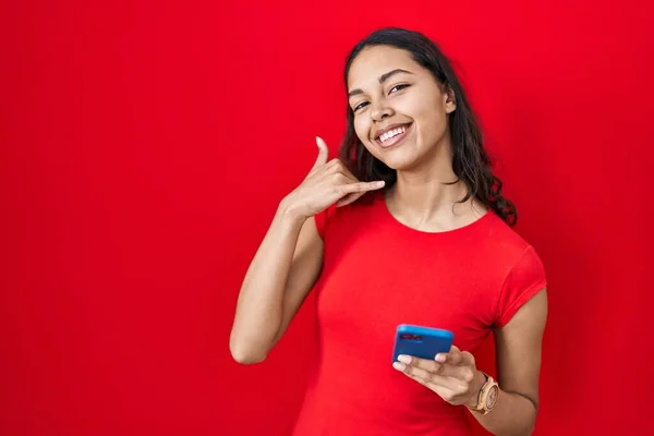 Mujer Brasileña Joven Usando Teléfono Inteligente Sobre Fondo Rojo Sonriendo — Foto de Stock