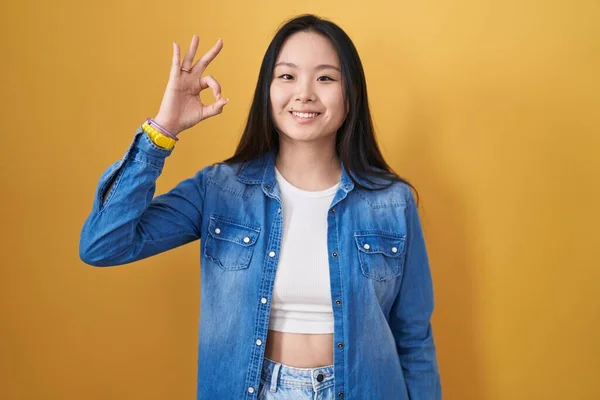 Mladá Asiatka Stojící Nad Žlutým Pozadím Pozitivním Úsměvem Dělá Pořádku — Stock fotografie